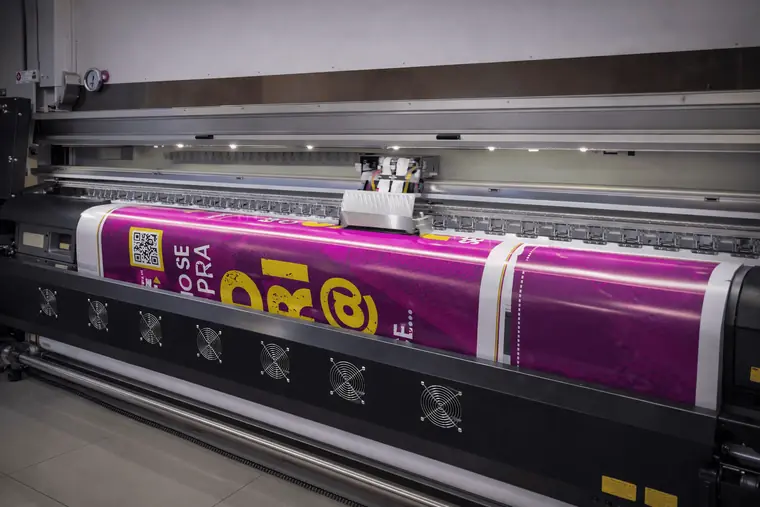 Plotter de impresión en gran formato produciendo un banner en el taller de Acrílica del Perú
