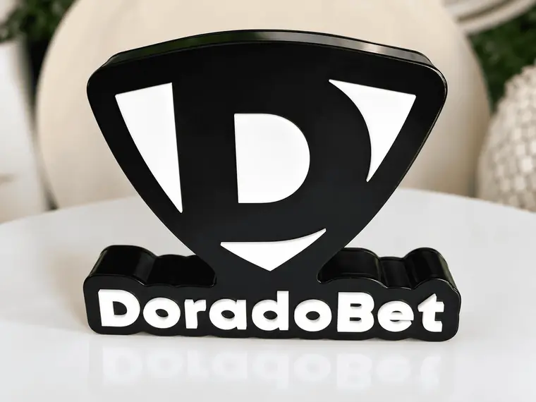 Distinción de acrílico negro y blanco con un logo cortado a su forma y el nombre de la marca en relieve en la base