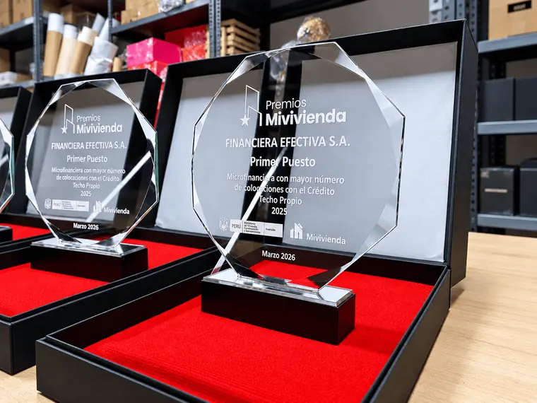 Detalle de un trofeo de acrílico transparente con el nombre del premio, el ganador, el puesto y la fecha