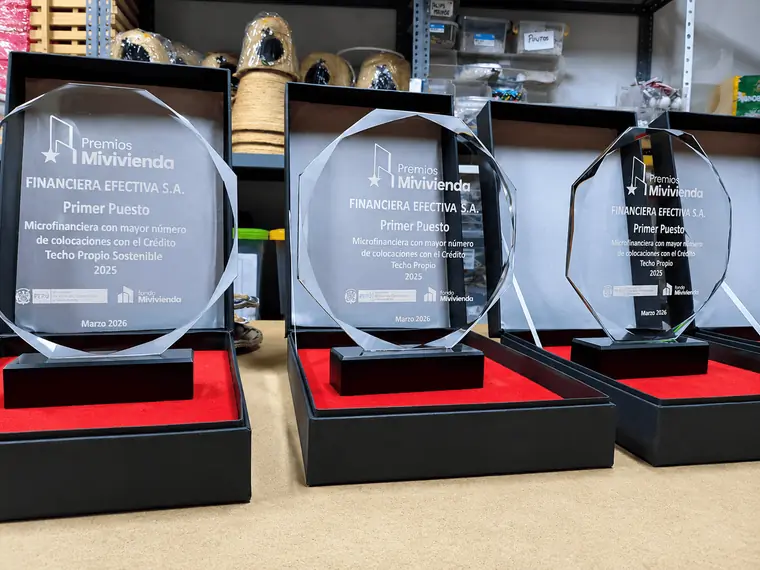 Tres trofeos corporativos de acrílico transparente con corte facetado y base negra, presentados en estuches