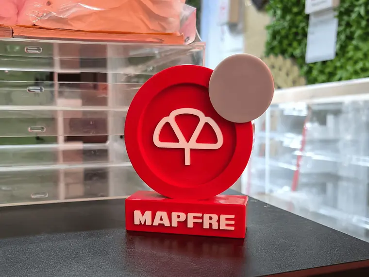 Trofeo de acrílico rojo con el logo de MAPFRE en relieve y el nombre de la marca en la base
